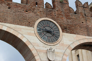 Ancient Brick Clock Tower with Roman Numerals and Historic Architecture