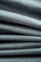 Vertical Grey insulating curtain, heavy textile, crumpled texture for house insulation.