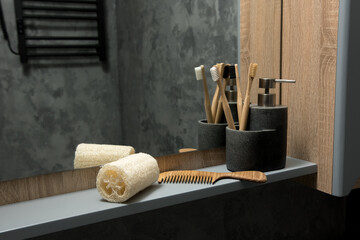 Eco-friendly bathroom essentials on a sleek shelf: bamboo toothbrushes, wooden comb, and natural...