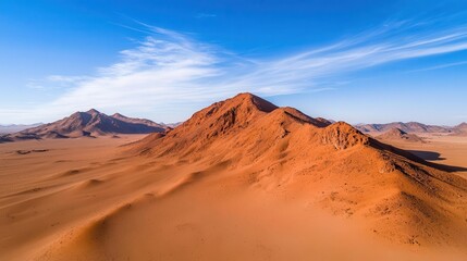 Fototapeta premium Aerial shot of highaltitude mountain desert, red and orange rocks, stark shadows, mountain arid, harsh environment, dramatic views