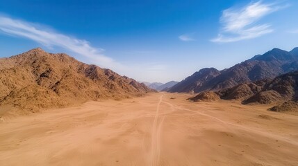 Desert mountain range, aerial perspective, dry and rugged terrain, sand dunes, midday sun, mountain aerial view, arid beauty, wilderness
