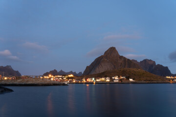 Mountain and village reflections in the arctic sea, Lofoten Norway