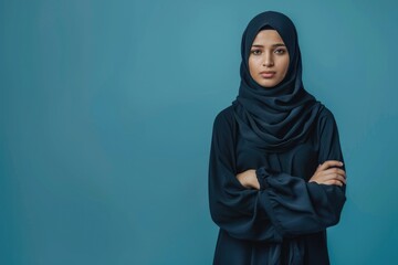 Young Muslim woman in abaya and hijab poses for portrait.