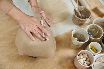 Young woman with nail polish making pottery.