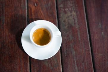 An espresso coffee on a wooden table in the morning