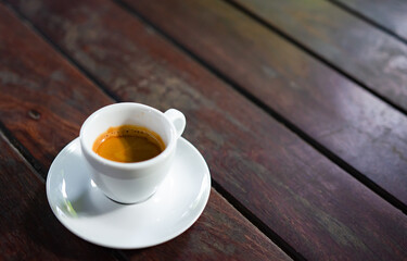 An espresso coffee on a wooden table in the morning
