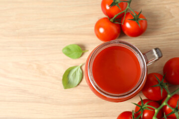 Tomato juice in a glass and fresh tomatoes on the table