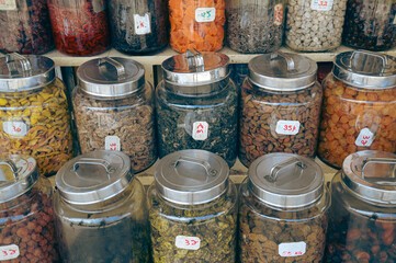Various glass jars containing spices and candied dried fruits displayed on store shelves showing the authentic local malay street food in Penang, Malaysia