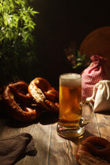 A mug with beer and traditional German bretzels in Bavarian rustic style