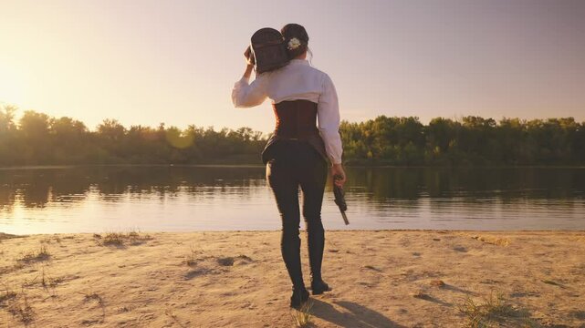 Back rear view Happy woman pirate holds in hands carries old style brown chest walking at island sand beach sea, waving gun. dark wooden box with lock. fantasy game search for pirates treasure art 4k