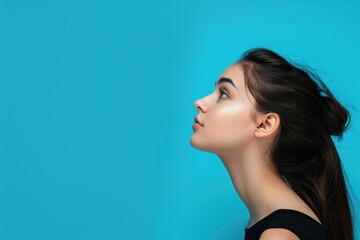 Fototapeta premium Attractive girl with copy space on blue background portrait.
