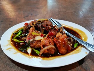 close up of delicious soy sauce chicken sitting on a white plate.