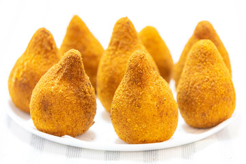 Traditional fried coxinha on a wooden table in selective focus - Brazilian snack