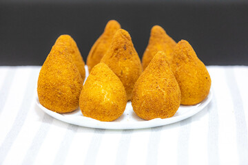 Traditional fried coxinha on a wooden table in selective focus - Brazilian snack