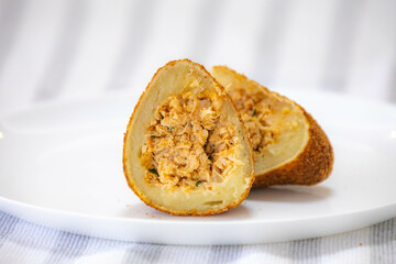 Traditional fried coxinha on a wooden table in selective focus - Brazilian snack