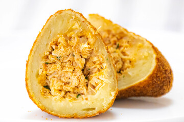 Traditional fried coxinha on a wooden table in selective focus - Brazilian snack