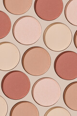 Eyeshadow palette, mix of matte and shimmer shades in pink, nude, red, brown hues. Minimal top view pattern for beauty, makeup, cosmetics themes, Pastel color swatches eyeshade refills round shape