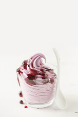 Vanilla berry soft ice cream in a glass cone on a white background