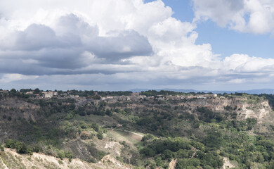 Fototapeta premium Bagnoregio, Italy - September 28: Panoramic View from Civita di Bagnoregio Overlooking the Valle dei Calanchi valley and the Town of Bagnoregio. Scenic Hills and Rolling Landscapes. Italian autumn day