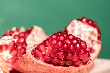 Sliced Red Pomegranate On Top Of The Turntable. Macro Shooting. In The Green Background