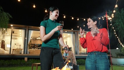 Family gather celebrate holiday. Focus Mother and grandmother drink wine and grill food for family...