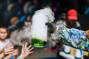 Woman children's animator conducts chemical experiment, experience, show with colored liquid in...