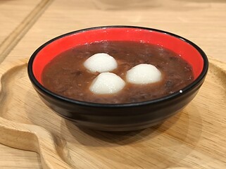 Zenzai on wooden table. Sweet red bean soup with mochi. Traditional Japanese dessert soup made with azuki beans