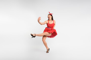 Full length photo of lovely lady have fun dancing raise leg dressed red retro style polka dot skirt...