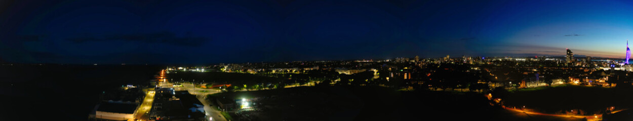 High Angle Night Panoramic View of Illuminated Portsmouth Central City Docks on Ocean Edge at Just After Sunset Time England United Kingdom. Drone Camera Footage Captured on Night of May 15th, 2024