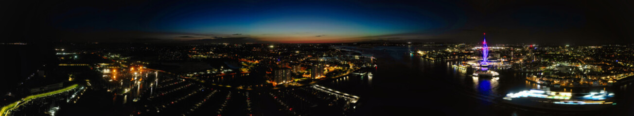 High Angle Night Panoramic View of Illuminated Portsmouth Central City Docks on Ocean Edge at Just After Sunset Time England United Kingdom. Drone Camera Footage Captured on Night of May 15th, 2024