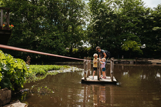 Family using a raft or floater to go over a pond outdoors