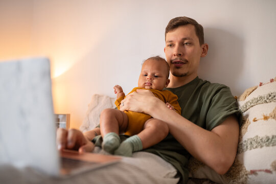 Father entertaining baby with cartoon