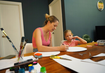 Obraz premium A mother and her young daughter engage in a colorful painting activity 