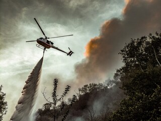 Obraz premium Vintage Fire Helicopter in Action: A Retro Scene of Aerial Firefighting
