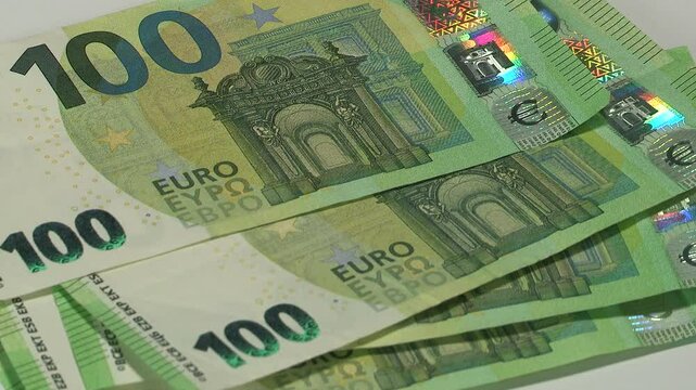 Leaf through 100 EURO banknotes on table
