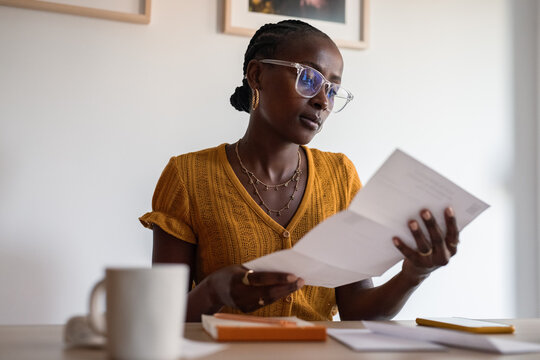 Focused woman reading letter at home