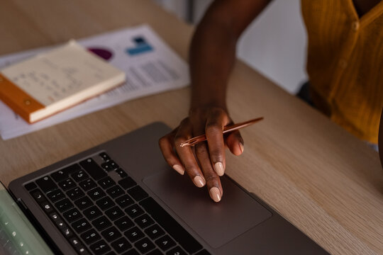 Crop woman using laptop at table at home