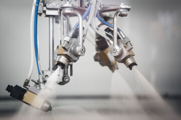 Close-up of industrial spray nozzles in operation of finishing

