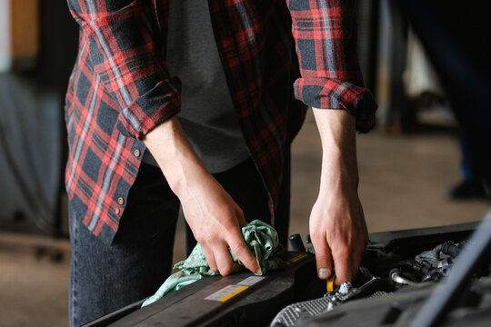 A man repairs a car in the garage