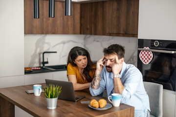 Stressed Couple Discussing Finances in Modern Kitchen