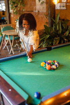 A couple plays pool in a snack bar