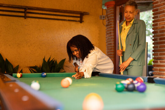 A couple plays pool in a snack bar