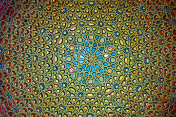 Ornamental colourful geometric medieval ceramic tiles of walls in old castle, Sevilla or Granada, Andalusia, Spain. Arabic ornament background wallpaper