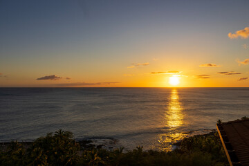 A stunning sunset over the pacific ocean of the coast of the island of Oahu in Honolulu Hawaii USA
