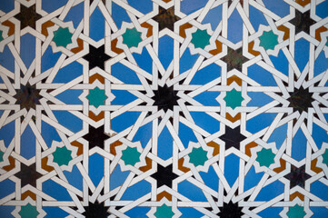 Ornamental colourful geometric medieval ceramic tiles of walls in old castle, Sevilla or Granada, Andalusia, Spain. Arabic ornament background wallpaper