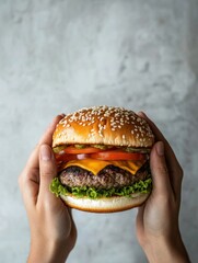 Two hands hold a hearty burger topped with lettuce, cheese, tomato, and pickles, highlighting a tempting culinary delight. Generative AI