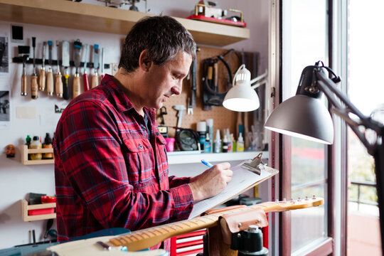 Guitar luthier checking pending reparations