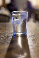 Glasses of cold mineral sparkling water served outdoor with ice cubes in cafe at night in historical Triana district, Sevilla, Spain