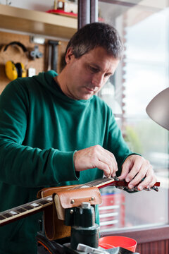 Luthier fixing bass guitar headstock