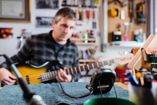Tuning bass guitar with professional tuner 